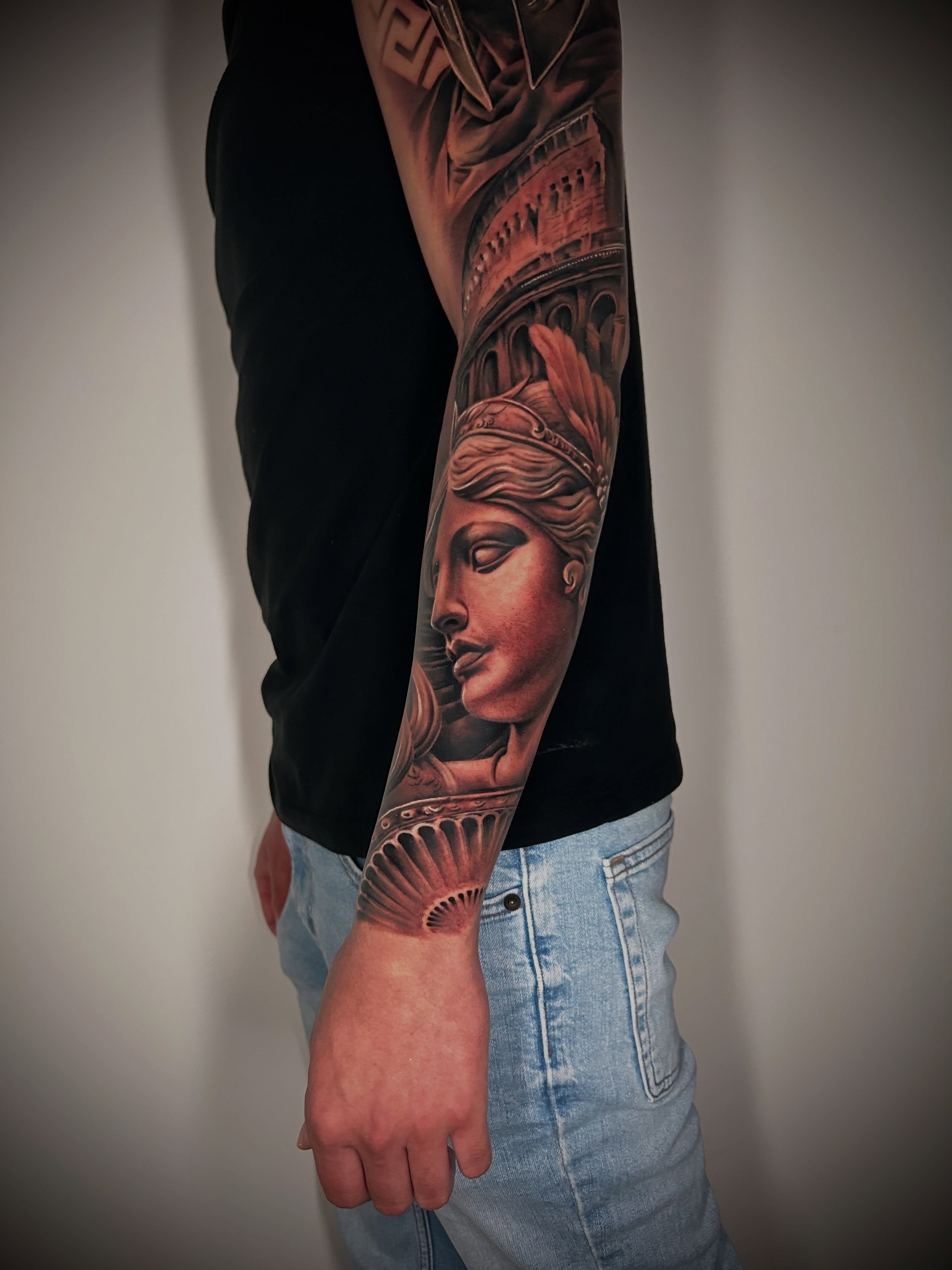 Full sleeve in black and grey — a crowned figure in profile with a feathered headdress