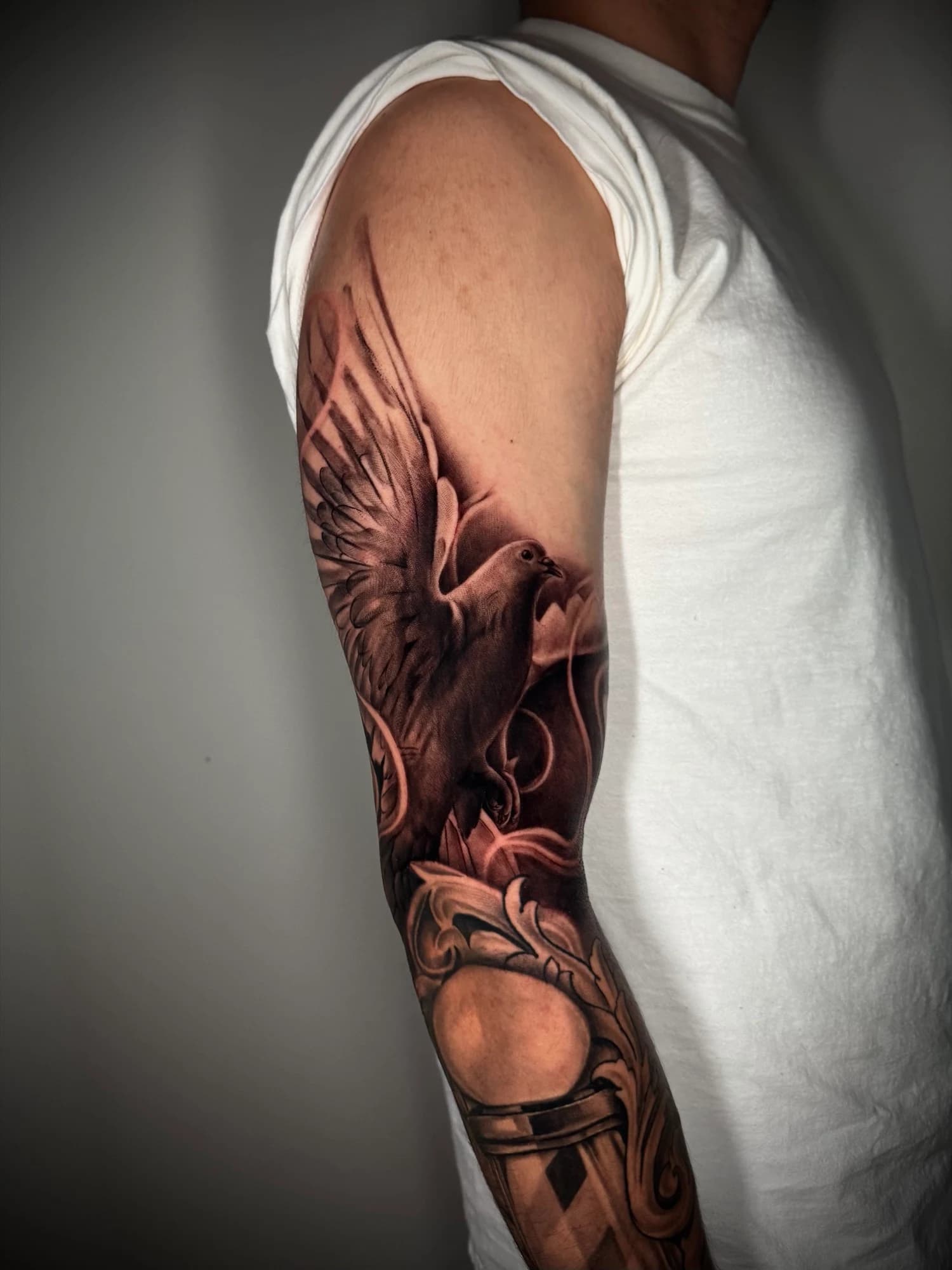 Black and grey tattoo: eagle above a warrior helmet with bold shading.