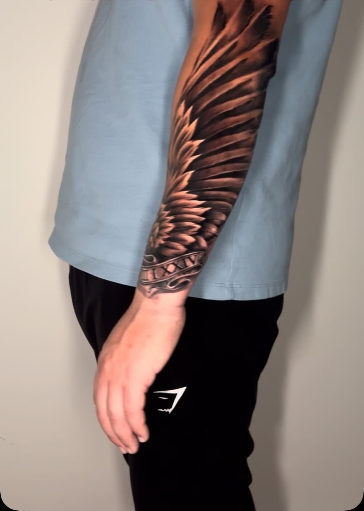 Angel wing running the length of an outer arm in black and grey